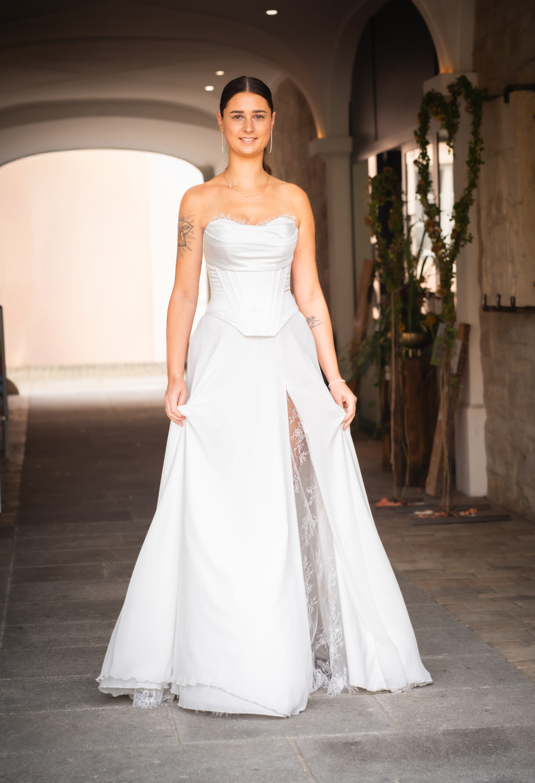 Model in einem Brautkleid mit geformter Korsage und Spitzenrock bei Hoffmann Braut